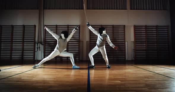 Two Men in Fencing Gear Duelling with Foils