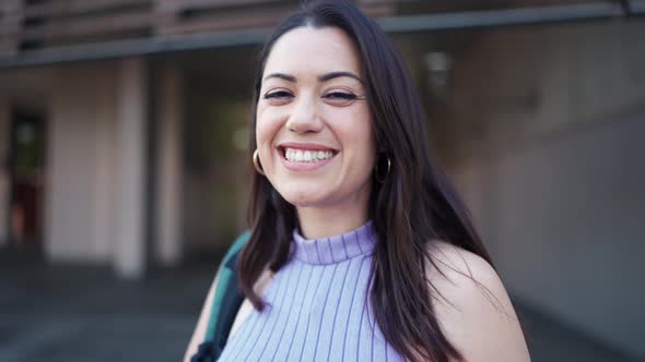 Cheerful brunette woman with backpack looking at the camera