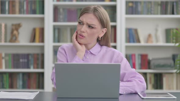 Woman Having Toothache While Working on Laptop