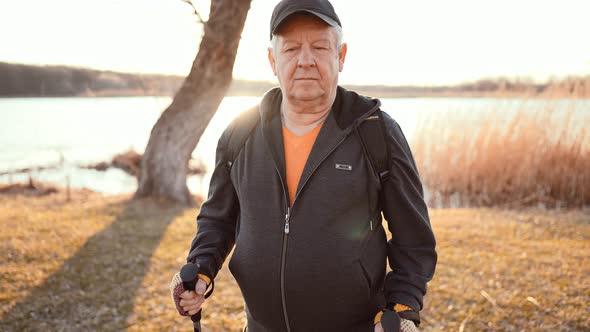 Nordic Walking  Active Man Working Out Outdoor Walks Along Shore of Lake