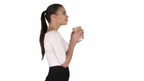 Relaxed stylish businesswoman drinking coffee walking on