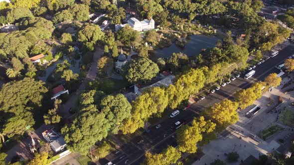 Aerial view of white bus driving on road of suburb district in Buenos Aires during sunset light