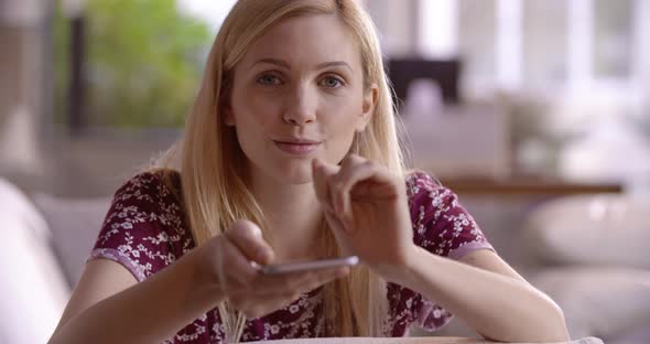 Beautiful Blonde Woman Relaxing on Couch Using the Smartphone