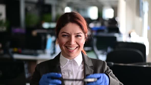 Portrait of Friendly Call Center Operator Woman in Gloves Put on Headset in Office