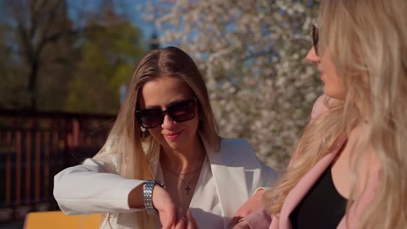 Two females persons sitting talking outside. Young adult women spending time together outdoors