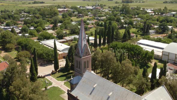 Dolly out of a romantic style church and tower with Santa Anita countryside town in background, Entr