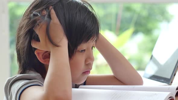 Asian Child Tired And Bored Of Doing Homework, Kid Stressed From Learning