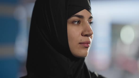 Headshot Portrait of Charming Confident Middle Eastern Woman in Black Hijab Posing Indoors