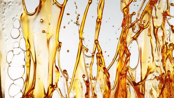 Super Slow Motion Shot of Splashing Golden Oil on White Background at 1000Fps alt