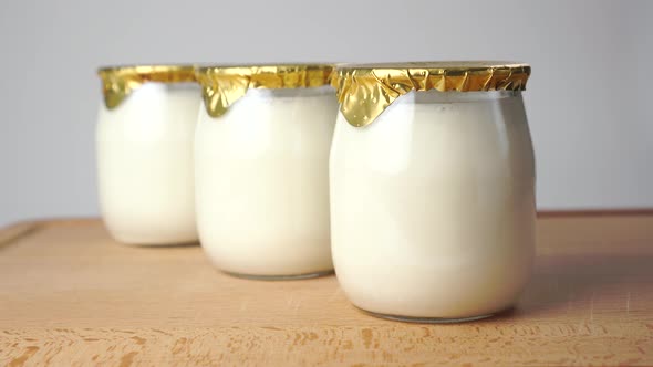 Natural yoghurt in glass jars with golden foil lids