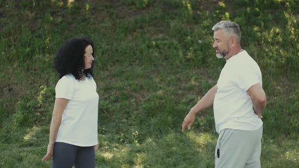 Middle Aged Man and Woman Doing Morning Exercises