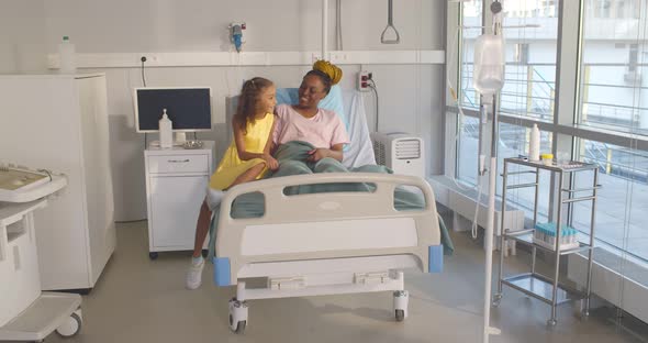 Little Afroamerican Girl Visiting Sick Mother in Hospital Ward