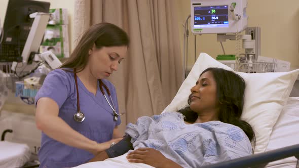 Nurse takes a patient's vitals, including blood pressure, pulse and temperature.
