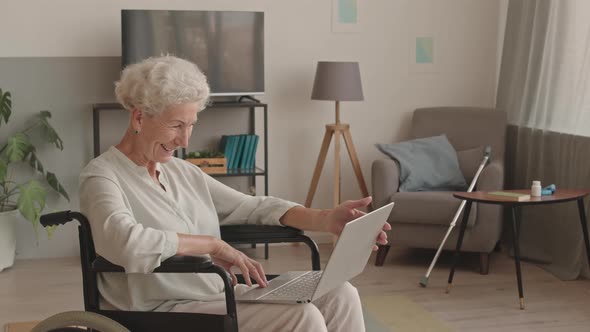Senior Woman Video Chatting on Laptop at Home