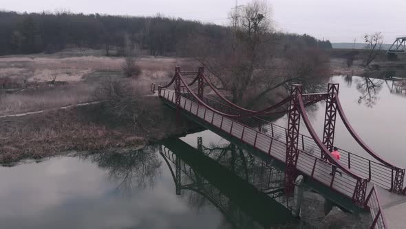 Woman running on bridge across river in morning training for marathon