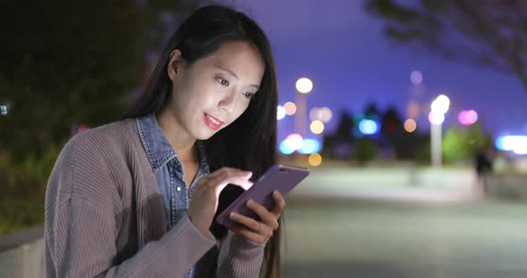 Young Woman Using Mobile Phone at Night