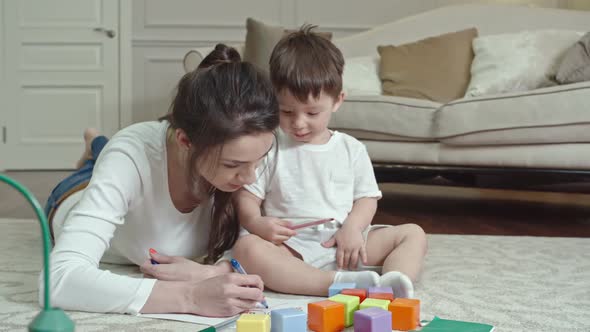 Cute Child Drawing with Mother