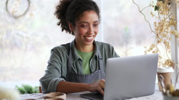 Woman potter texting by laptop