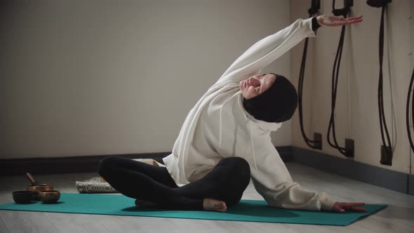 Yoga  Young Woman in Hijab Doing Stretching Exercises Surrounded By Objects for Meditation