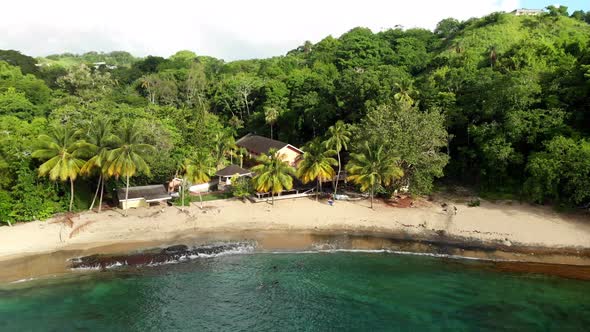 This is drone footage of  Arnos Vale Beach with trees and houses in the background located in on the