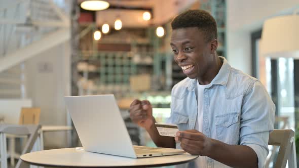 Successful Online Payment by African Man on Laptop