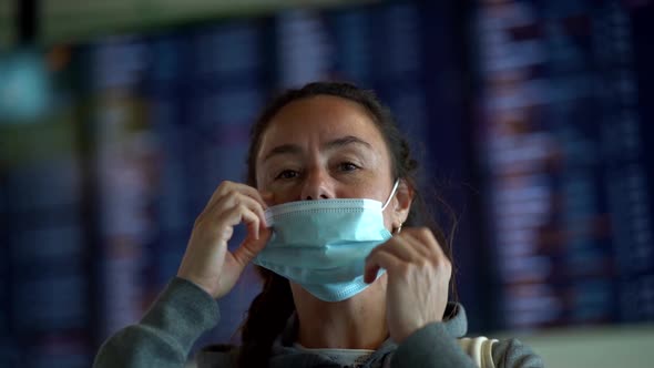 Female Traveler Is Putting on a Face Mask for Protection From Coronavirus Infection