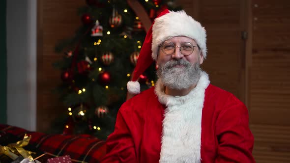 Portrait of Santa Claus Looking Into the Camera Showing Thumbs Up Gesture