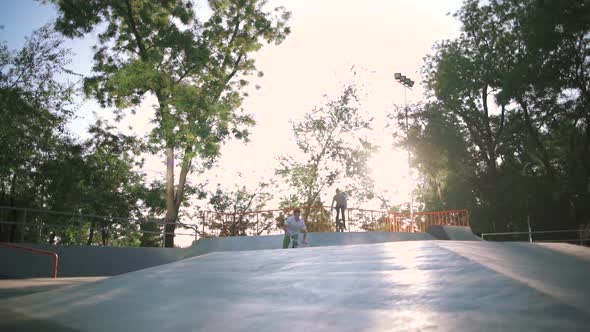 BMX Riders Doing Tricks in Extreme Park During Sunset Slow Motion