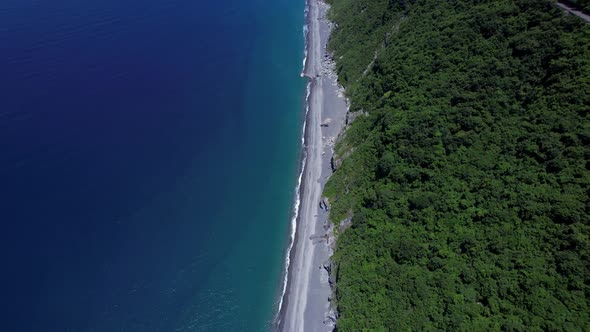 Flying over secluded tropical cliff-side beach to reveal the eastern coastline of Taiwan - moving ba