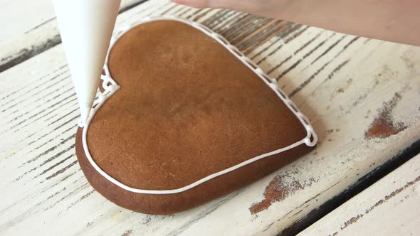 Confectioner Decorating Heartshaped Biscuit