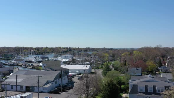 An aerial view over Bay Shore, NY, on a sunny day with clear skies. The camera dolly in and boom up