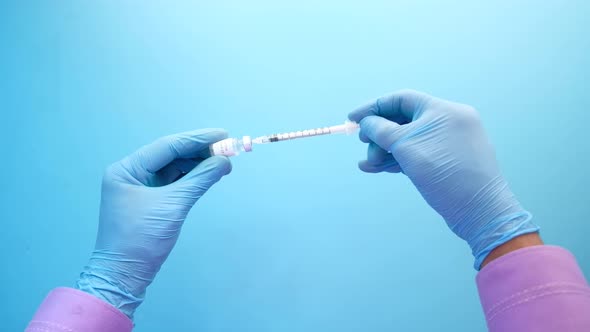 Hand in Blue Latex Gloves Fill in Syringe with Medicine Isolated on White