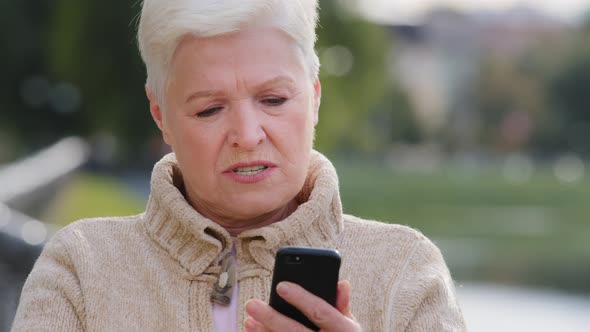 Angry Mature Woman Displeased Retired Feel Frustrated By Slow Internet Connection on Cellphone