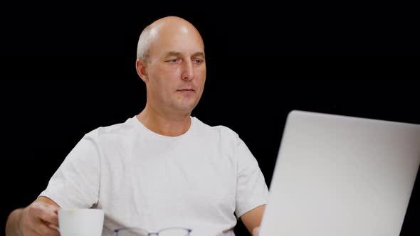 Middle Aged Man Using Laptop and Drinking Tasty Coffee