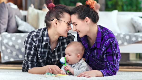 Female Couple Feeling Love Having Tenderness Together Posing with Cute Child at Home