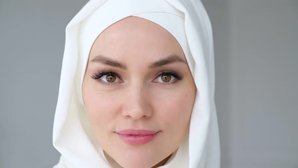 Attractive Muslim Woman Wearing Hijab Is Looking at Camera and Smiling