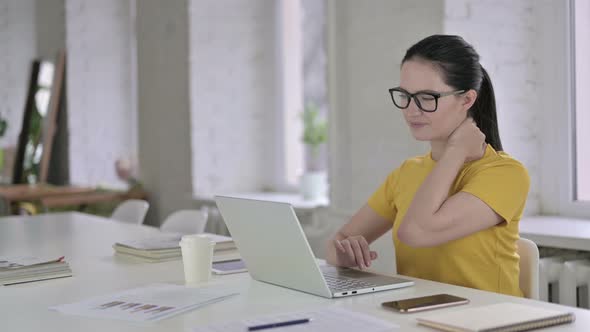 Tired Young Female Designer Having Neck Pain in Modern Office