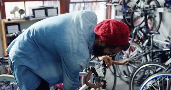 Mechanic repairing bicycle in workshop