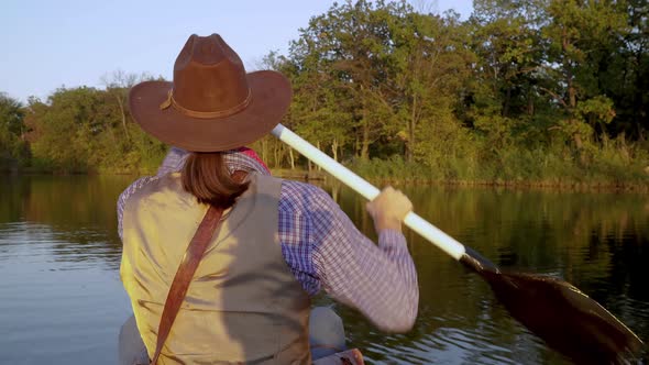 Cowboy in a Canoe Floats on the River