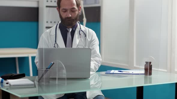 Portrait of General Practitioner Working on Laptop at Desk