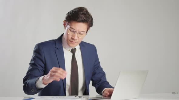 asian businessman wear formal suit sitting in office feeling body pain by office syndrome