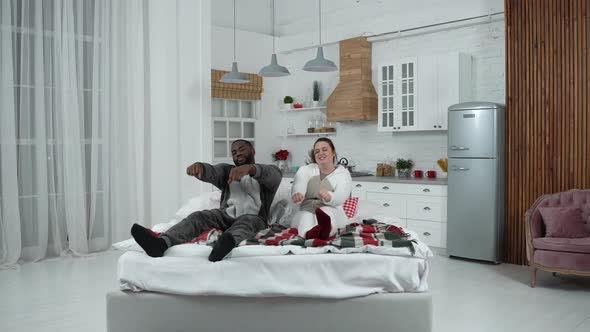 Funny Diverse Couple in Love Fooling Around on Bed