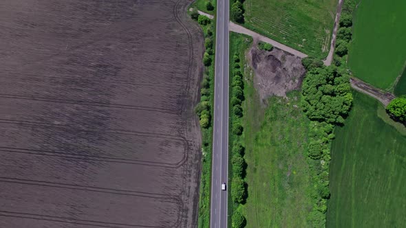 Aerial Road Cars Moving in the Green Fields of Summer