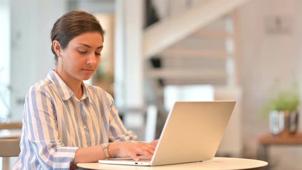 Young Indian Woman Working on Laptop in Cafe 