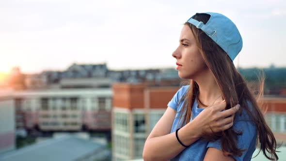 Side View Portrait of Young Attractive Teenage Woman in Cap Enjoying Beautiful Sunset Outdoor