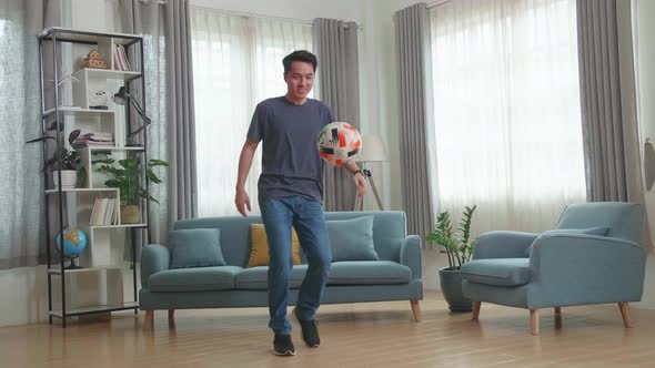 Asian Man Show Skill With Soccer Ball In Living Room
