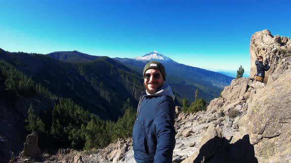 Man in Sunglasses with Beard Climbed to Top of Mountain