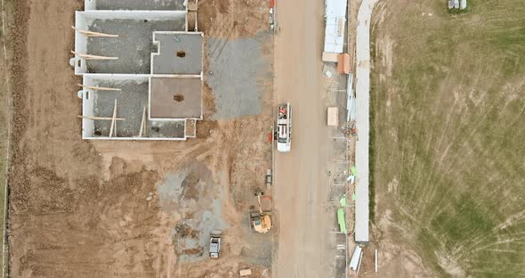 Construction of aerial top view on pouring the foundation for a new house with suburbs development.