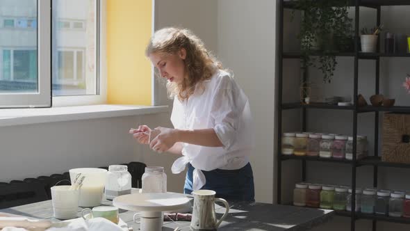 Female Potter Glazing Raw Unburned Ceramic Cup Using Brush. Earthenware Mug Putting Colorant on