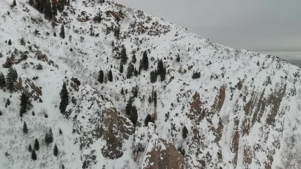 Aerial fly over near snow-covered Grandeur Peak in Utah.